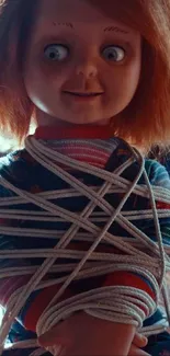 Quirky doll wrapped in a rope sitting on a table in a library.