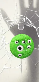 Quirky green cookie with eyes on shattered glass background.