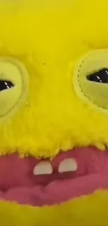 Bright yellow plush monster with quirky face and cheerful expression.