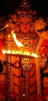 A radiant, adorned deity in vibrant orange light.