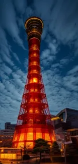 Illuminated tower against a dusky evening sky with vibrant orange and deep blue hues.