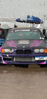 Racing car with purple accents in rainy weather.