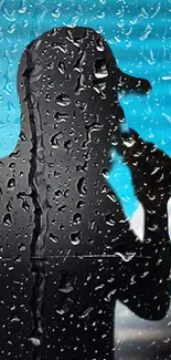 Silhouette of a singer behind rain-soaked glass with a blue background.