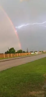 Rainbow meets lightning over a road, creating a vibrant natural scene.