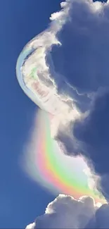 Mesmerizing rainbow appears within large, soft clouds against a blue sky.