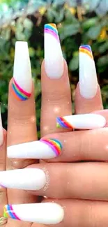 Close-up of hands with elegant rainbow nail art.