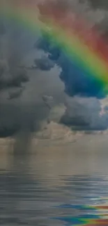 Cloudy sky with a vibrant rainbow over calm water.