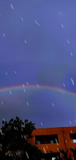 Rainbow arches over urban building against deep blue sky at twilight.