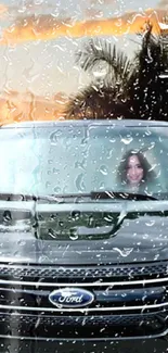 Car with raindrops and sunset view, featuring palm trees.