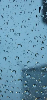 Raindrops on a window with a cityscape view in the background.