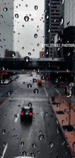 Rain-speckled city street viewed through a window on a gloomy day.