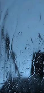 Raindrop covered glass with soothing blue hue for a serene phone wallpaper.