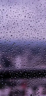 Raindrops on glass with a purple cityscape background.