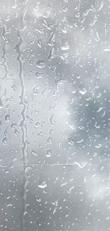 Raindrops on glass with a cloudy sky in background.