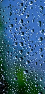 Raindrops on a clear glass with blurred blue and green background.