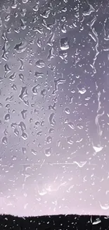 Raindrops on window with a purple sky background.