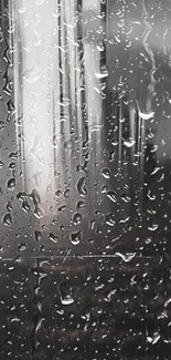 Close-up of raindrops on a glass surface reflecting a city skyline in grayscale.