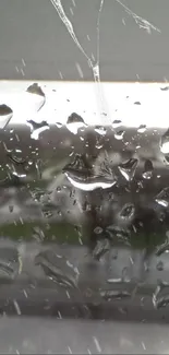 Rain droplets on window with blurred nature outside.