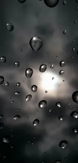 Raindrops on a dark glass surface with a cloudy background.