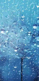 Rainy blue wallpaper with water droplets on glass.