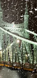 Rainy night view of an illuminated green bridge with raindrops in the foreground.