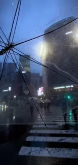 Rainy cityscape with umbrella over crossing at night.