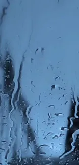 Blue rainy day wallpaper with raindrops on glass.