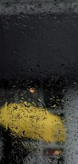 Wallpaper with raindrops on a window and blurred yellow umbrella.