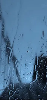 Raindrops on glass with a calming blue hue, perfect for a serene phone wallpaper.