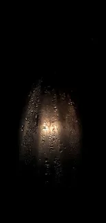 Dark wallpaper with raindrops on glass, illuminated by light.