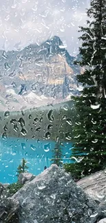 Rain-soaked window view of mountains and blue lake.