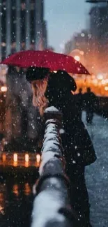 Woman with red umbrella on a snowy city bridge.