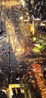 Rain-drenched cityscape with bright night lights viewed through a window.