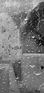 Black and white wallpaper with raindrops and a phone reflection.