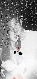 Romantic couple behind raindrop-covered glass in black and white tones.