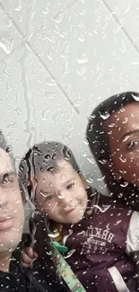 Family behind rainy window with raindrops on glass.