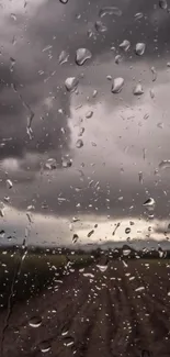 Raindrops on a window with dark, moody clouds in the background.