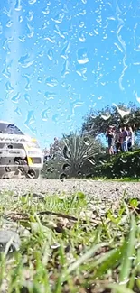 Rally car with raindrops on glass in front of a bright blue sky.