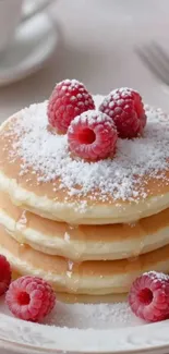 Fluffy pancakes topped with raspberries and sugar.