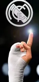 Real Madrid logo with wrapped hand pointing on black background.