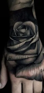 Black and gray rose tattoo on a hand, artistic design.