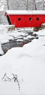 Red barn amidst snowy landscape with stream.