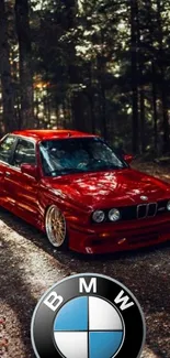 Red BMW car parked in a serene forest setting.