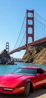 Red sports car near the Golden Gate Bridge under a blue sky.
