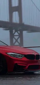 A red car parked in front of the Golden Gate Bridge on a foggy day.