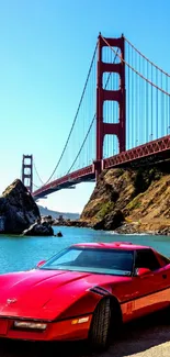 Red sports car parked by the Golden Gate Bridge under blue sky.