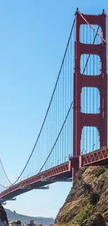 Red sports car by the Golden Gate Bridge on a sunny day.