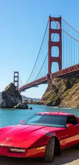 Red car parked by Golden Gate Bridge under clear sky.