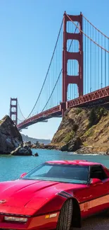 Red sports car by Golden Gate Bridge with scenic view.