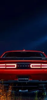 Wallpaper of a red car with glowing lights at night.